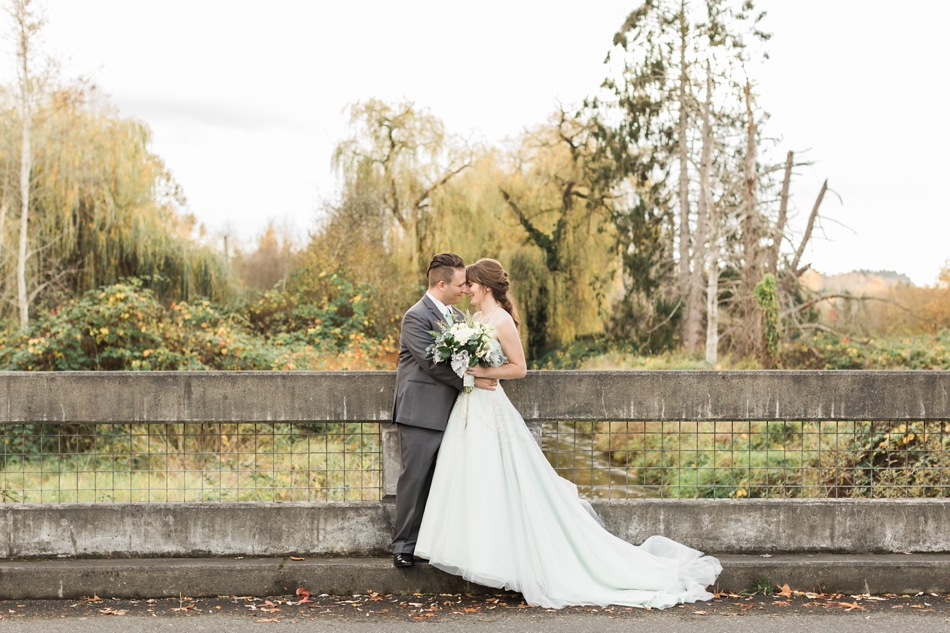 A photo of a bride and groom embracing on a concrete bridge before their fall wedding at the Loft at Russell's in Bothell, a wedding venue near Seattle. | Joanna Monger Photography | Snohomish & Seattle Wedding Photographer