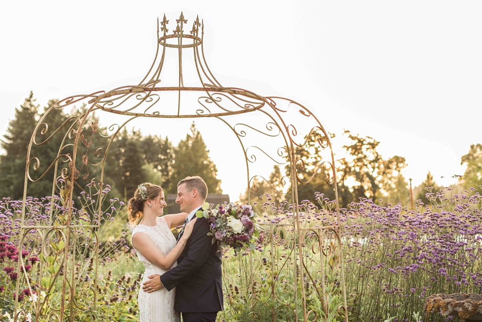 Holding each other under a trellis at Pine Creek Nursery in Monroe. Photos by Joanna Monger Photography, Snohomish and Seattle Wedding Photographer.